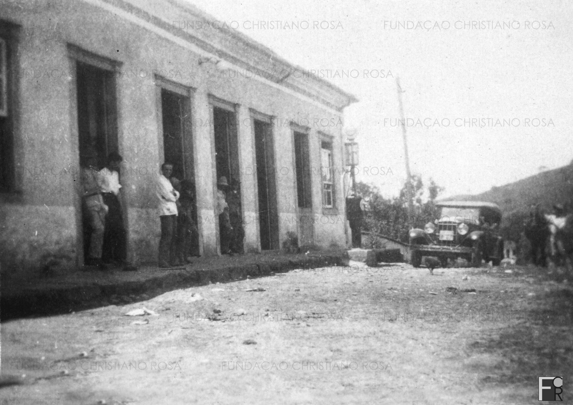Antiga residência do Cel. Luiz Francisco Relvas, na década de 1930. Situada à margem direita da Rodovia Piquete-Itajubá, alojou um grande armazém. Em terreno contíguo ao estabelecimento comercial, erguia-se um movimentado rancho para tropeiros. Na foto, vê-se a primeira bomba de gasolina de Piquete. O prédio localiza-se na atual Rua Cel. Luiz Relvas, sendo propriedade da família de Gabriel Benfica Nunes.