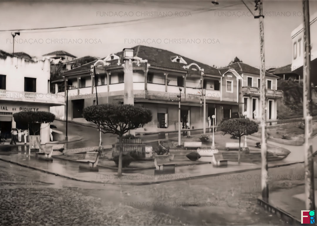 A Praça da Bandeira em dia de chuva, na década de 1960. Ao fundo, junto à rua Cel. Luiz Relvas, a Predial de Piquete, a Associação Comercial, a Loja Dom Bosco, a Sapataria Santa Luzia e a loja do Elias Hankis.