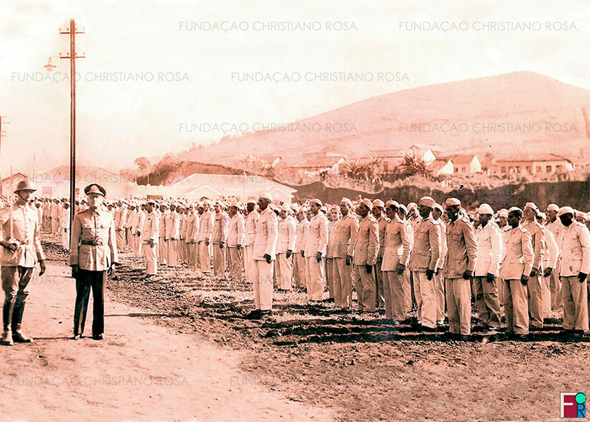 Operários da FPV perfilados em frente ao Parque Zoológico e Jardim da Infância, à rua Mestre Targino Cunha, observam a passagem do Cel. Waldemar Brito de Aquino, Diretor da FPV, em cerimônia comemorativa do aniversário da FPV. Foto de 15 de março de 1948.