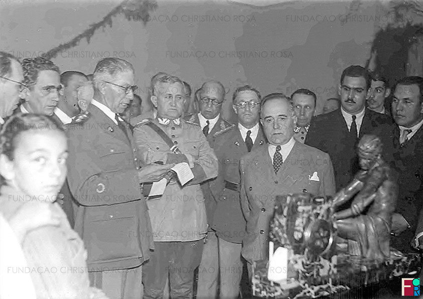 O Coronel Gomes Carneiro, Diretor da Fábrica de Piquete, discursa agradecendo a visita do Presidente Getúlio Vargas e sua comitiva. Ao seu lado, o Ministro da Guerra, General Eurico Gaspar Dutra. Foto de 17 de julho de 1939.