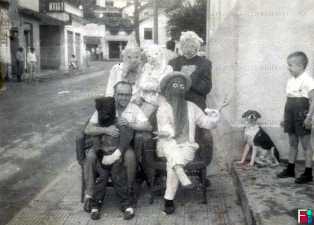 Mascarados de bloco de sujos em frente ao Hotel Brasil, na Praça da Bandeira, em Piquete, SP. Sentado, de óculos, o comerciante Aurélio Campos.