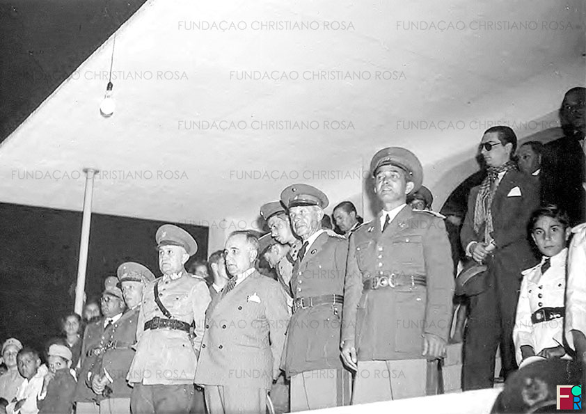 O Presidente da República, Getúlio Vargas, ladeado pelo Diretor da Fábrica de Piquete, Coronel Gomes Carneiro, e pelo seu Ministro da Guerra, Eurico Gaspar Dutra, durante a inauguração das torres de iluminação do Campo do Estrela Futebol Clube, em 17 de julho de 1937.