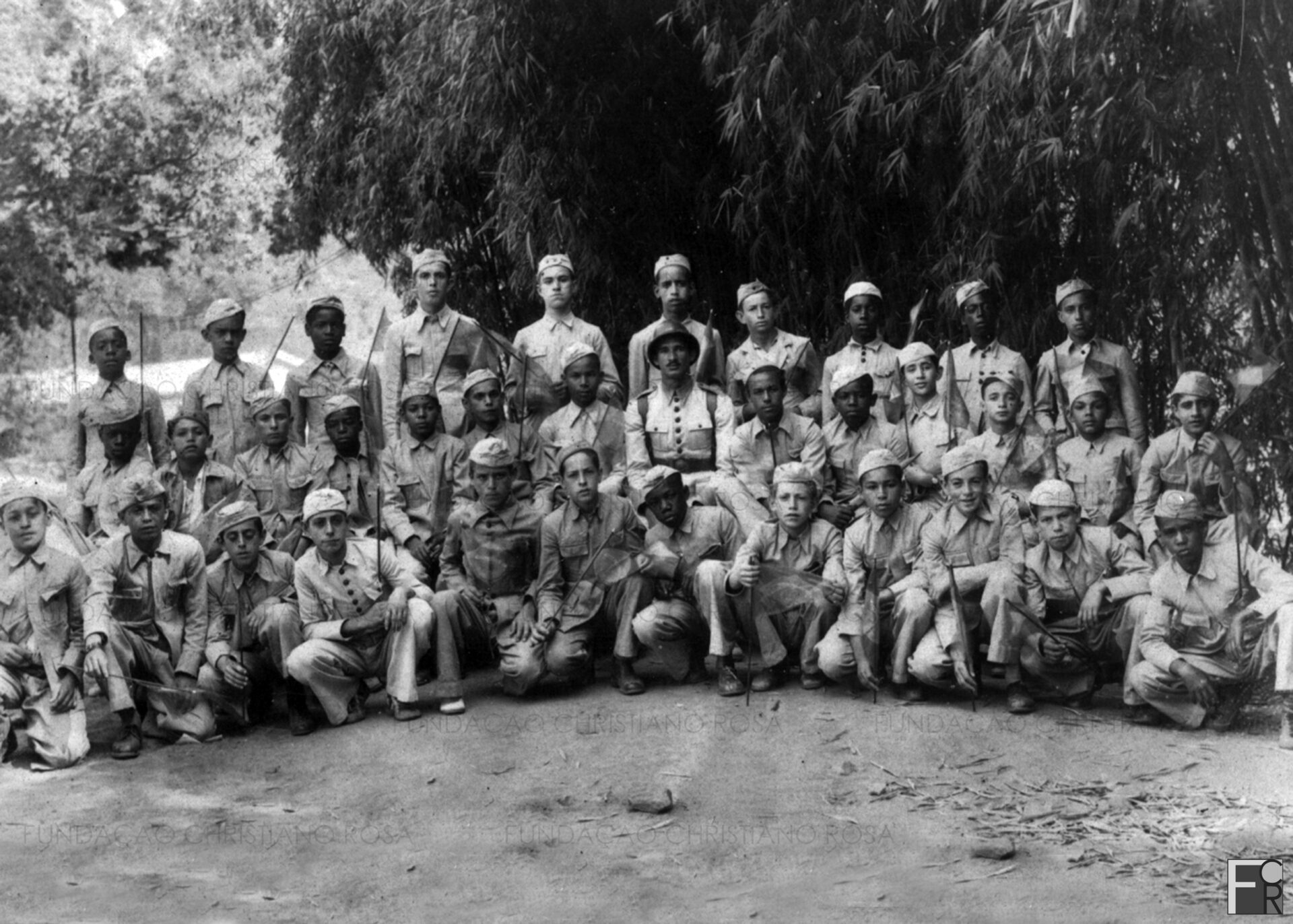 Grupo de alunos do Patronato da Fábrica Presidente Vargas em foto de 19 de novembro de 1939, no Campo do Estrela, em Piquete, SP. Ao centro, o capitão Marcondes, responsável pela formação do grupo, que daria origem à Escola Industrial Masculina.