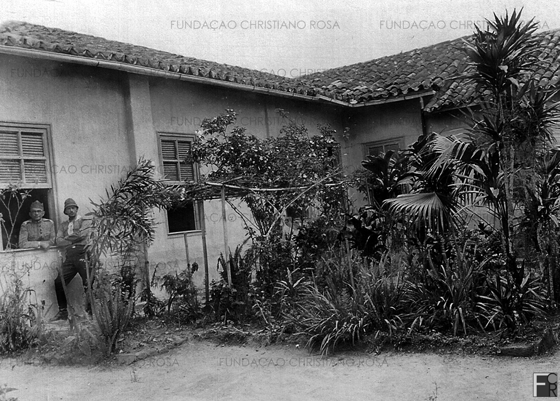 “Lembrança do jardim do hotel, em Piquete. 1932” O comandante do Setor Piquete, Major Leôncio Neiva (apoiado no parapeito da janela) no Hotel das Palmeiras, de propriedade de D. Maria Eufrásia Ribeiro da Silva, que fora transformado em QG. Foto do acervo da Fundação Christiano Rosa, de Piquete, SP.