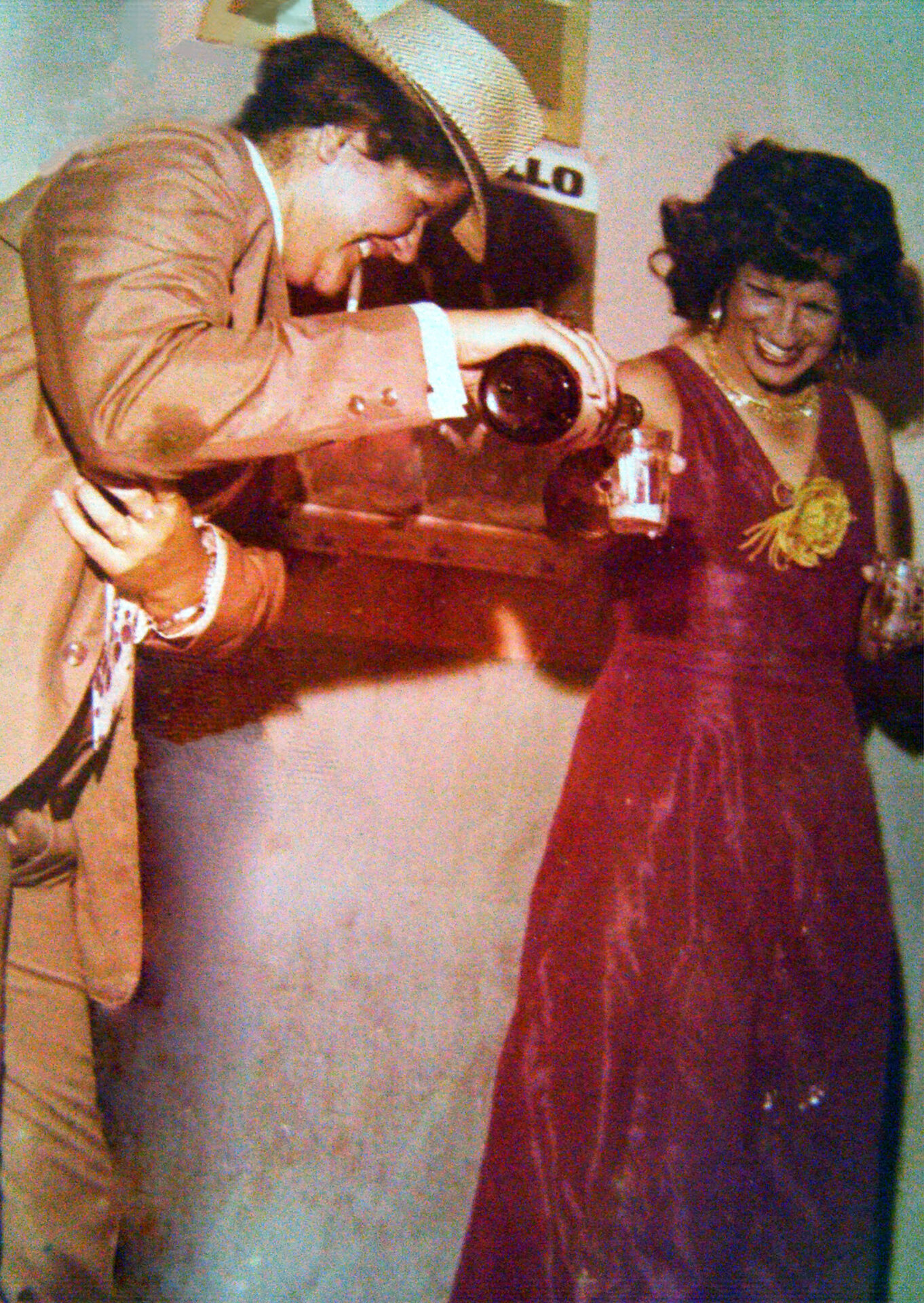 A professora Maria Auxiliadora, a "Dorão", em Carnaval da década de 1980, serve cerveja ao amigo Miguel Magalhães.