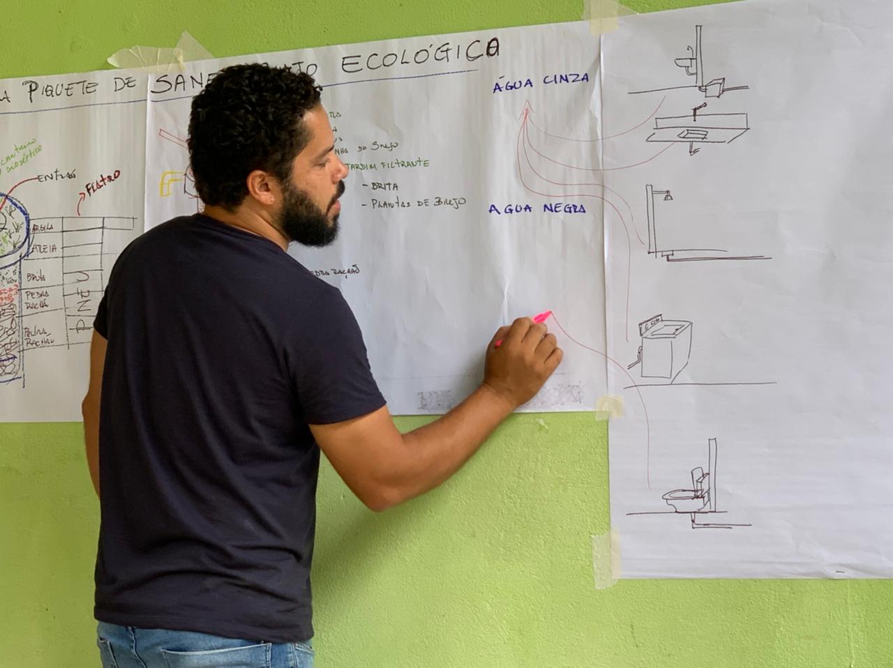 Professor João Lucas explica o funcionamento do saneamento ecológico instalado em residência no Bairro do Benfica, em Piquete/SP.