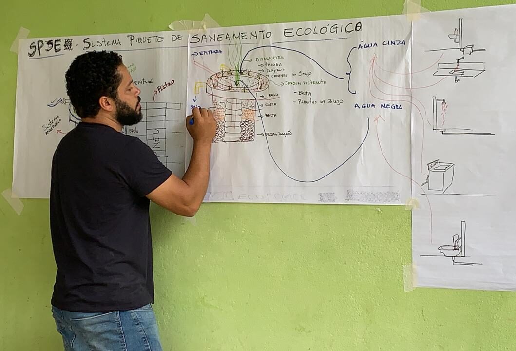 Professor João Lucas explica o funcionamento do saneamento ecológico instalado em residência no Bairro do Benfica, em Piquete/SP.